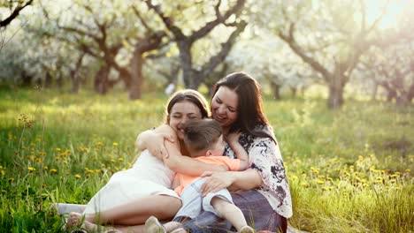 madre y su pequeña hija y hijo en un jardín en flor