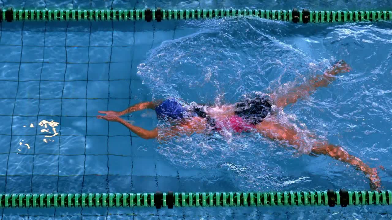 Fit female swimmer doing the breast stroke in swimming pool