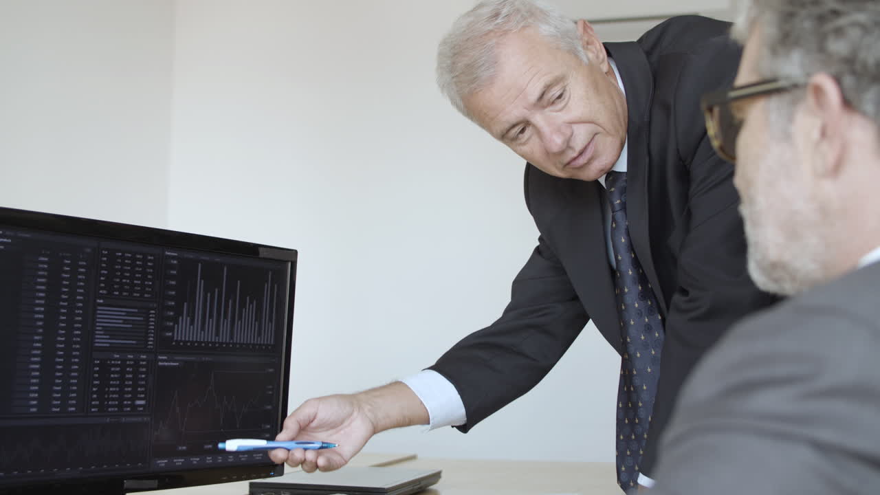 серьезные седовласые инвесторы обсуждают динамику фондового рынка