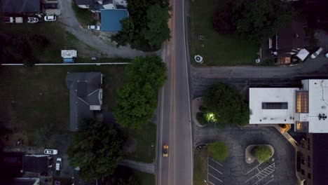 aerial top shot over roads in the residential area with driving cars after sunset