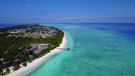 aerial arriving at small beautiful maldives island with beach eco hotels and vivid blue seas 4k