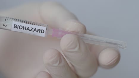 hand attaching and removing needle of syringe - biohazard vaccine - close up