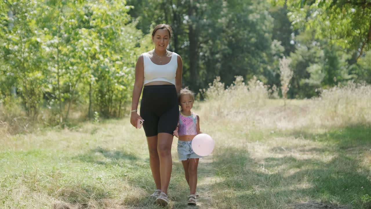 Zwangere moeder en dochter wandelend op een natuurpad