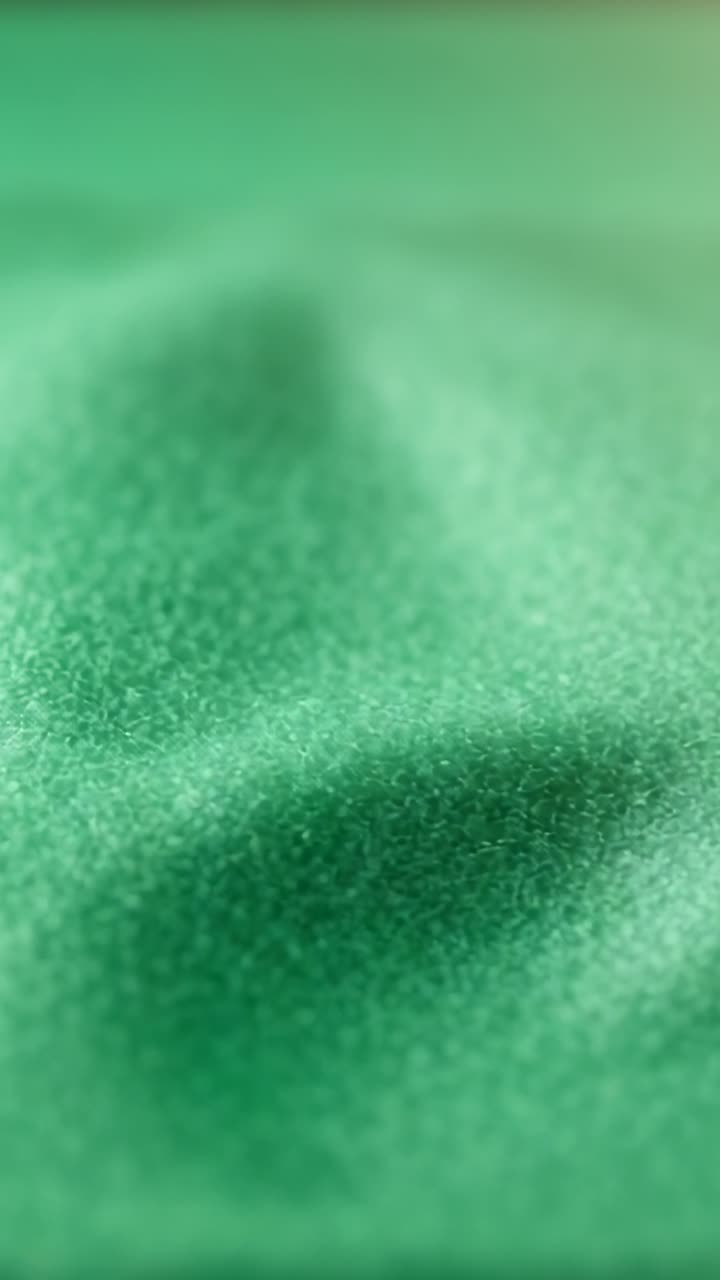 Vídeo vertical: Lente ajustando o foco revelando tecido verde em close-up macro para mostrar textura granular.