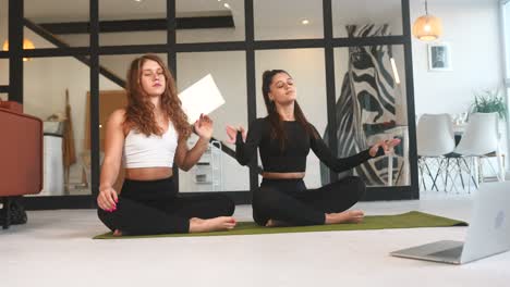dos mujeres practicando estiramientos de yoga en casa