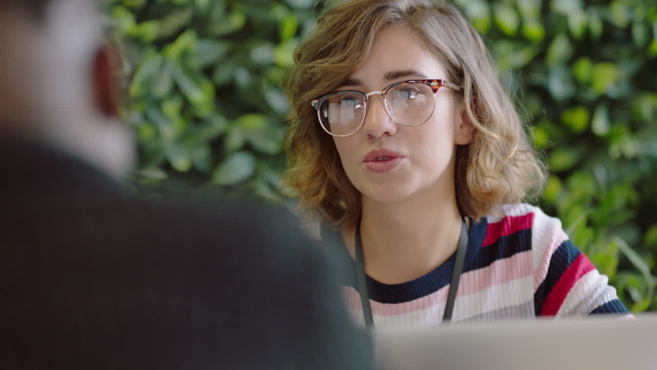 hermosa mujer caucásica estudiante discutiendo ideas disfrutando de la conversación con un hombre afroamericano colega compartiendo conexión social en la oficina de inicio de moda
