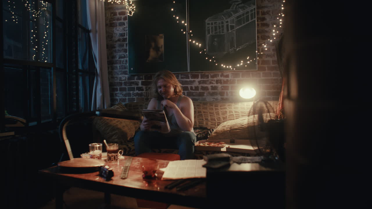 Man Reading in a Cozy Apartment at Night