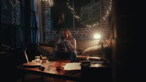 man reading in a cozy apartment at night