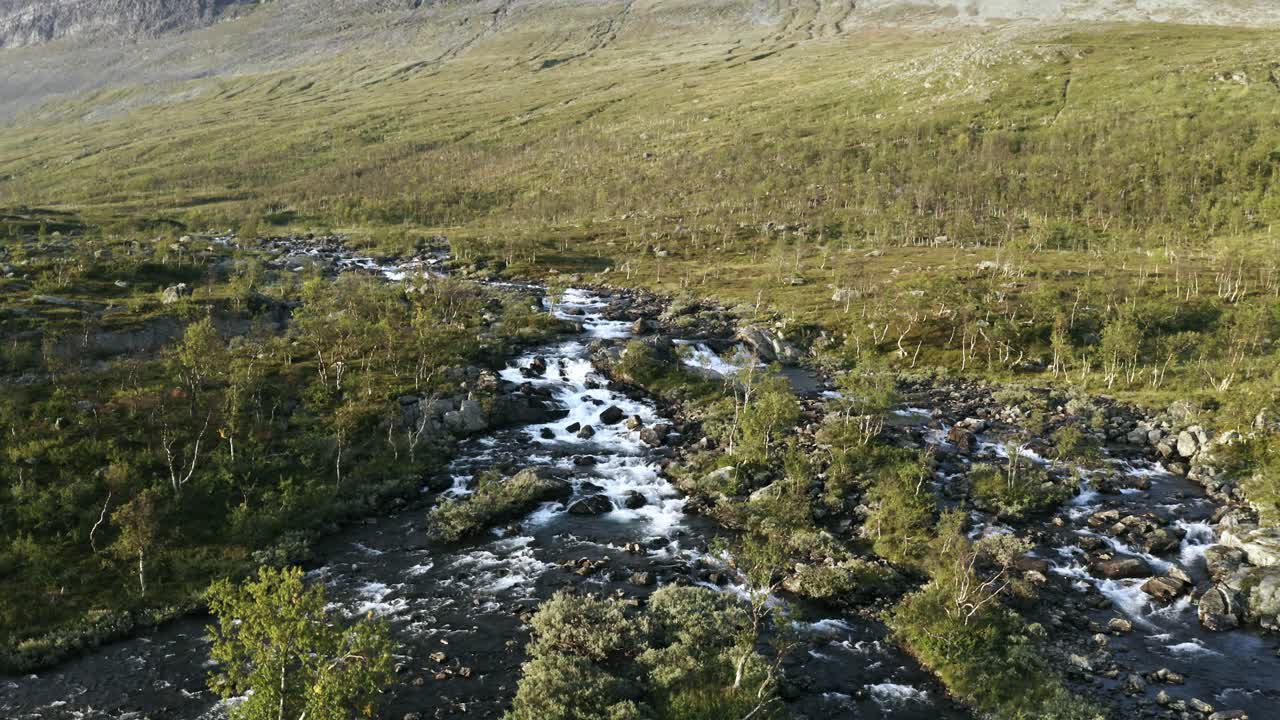 Mountain stream aerial with huge mountain reveal in Lapland, Sweden.