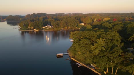 a golden sunrise splashing yellows across the forests and homes lining mona lake