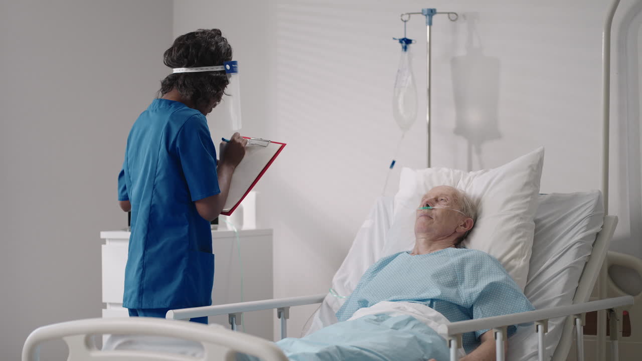 una mujer negra cardióloga está hablando con un anciano paciente acostado en una cama de hospital discutiendo la rehabilitación después de la recuperación. un neurólogo de enfermedades infecciosas discute una estrategia de tratamiento