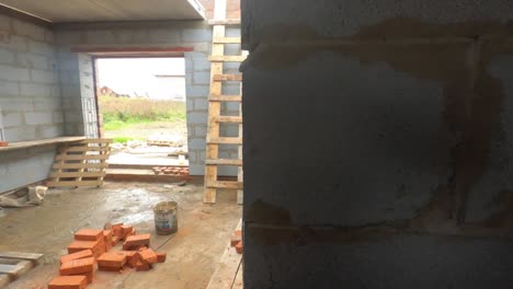 house under construction with brick walls and wooden ladder