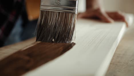 close up video of man painting boards with a brush