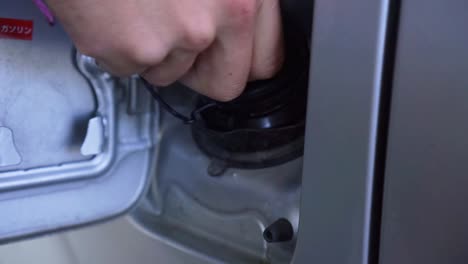 slowmo - caucasian man filling up gas tank with fuel