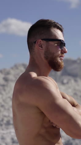 fitness male model posing. handsome bearded bodybuilder man with perfect muscular body posing outdoors