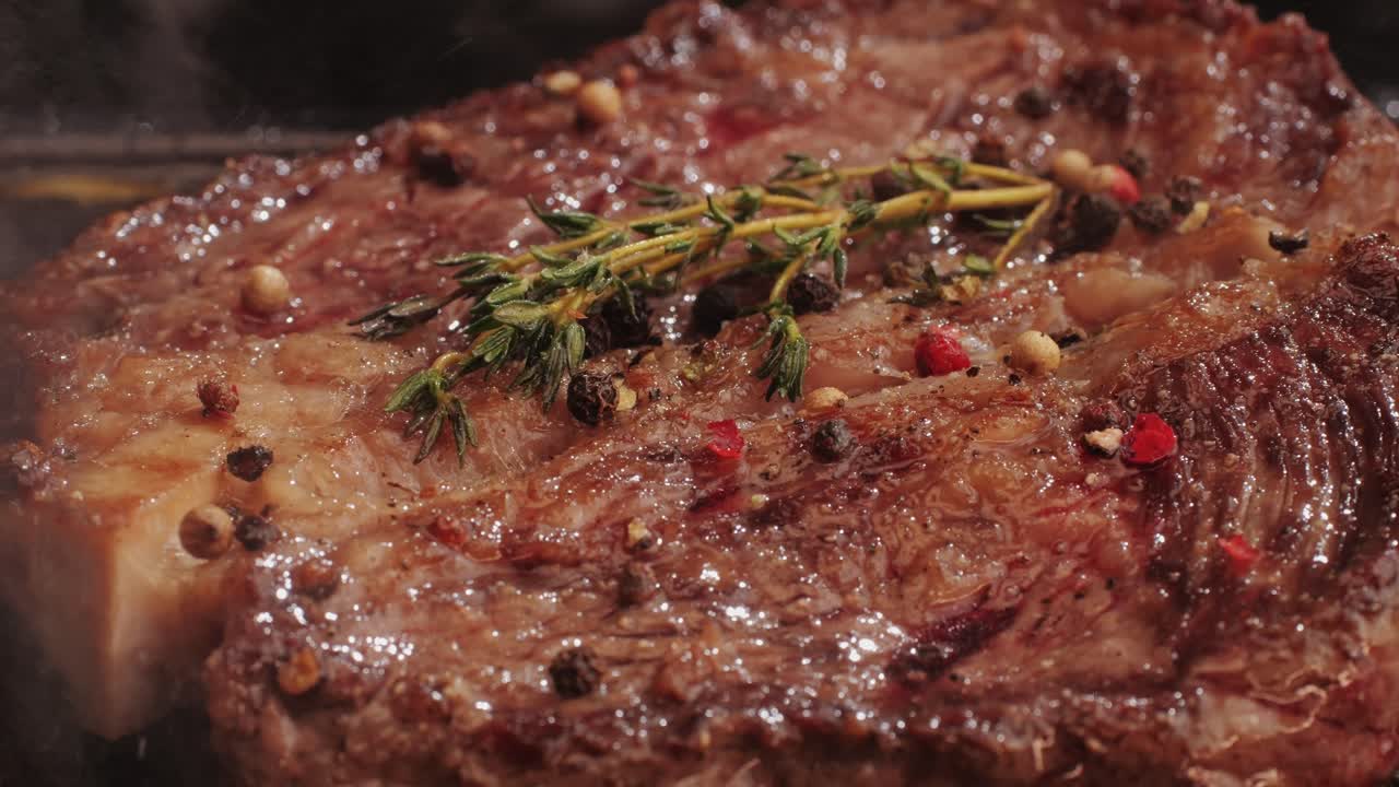Fresh marbled beef with pepper, salt and rosemary close-up macro. Cooking juicy steak on grill with oil. Premium organic wagyu meat. High quality 4k footage