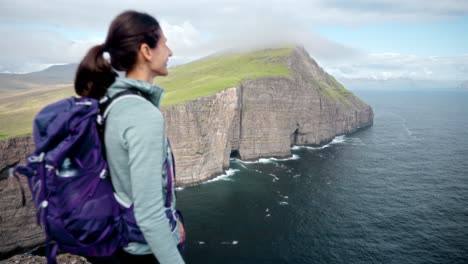 una mujer serena disfrutando de la naturaleza en leitisvatn, islas feroe, vista del acantilado