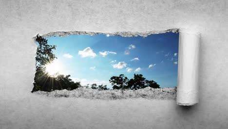 un video creativo de 4k de nubes que se mueven rápidamente en el cielo azul que son visibles a través de un agujero con bordes rasgados en viejo papel vintage retro grunge.