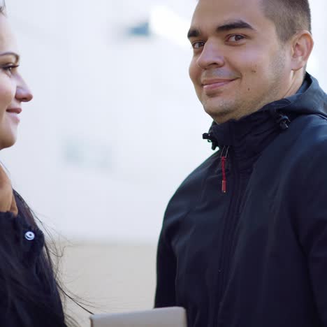 ein mann gibt seiner geliebten frau ein geschenk und küsst sie am valentinstag auf der straße
