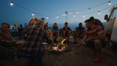 friends camping around campfire at night
