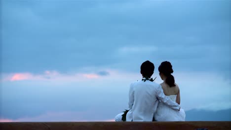 Wedding-couple-watches-sunset-at-Ala-Moana-Beach-Park-in-Honolulu-Hawaii