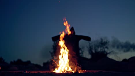 horrible atmosphere at night outside. bright flame with orange sparkles and dark nightmare with outstretched arms. fright concept.