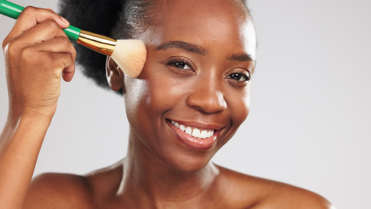 Trucco, viso e donna nera felice con un pennello