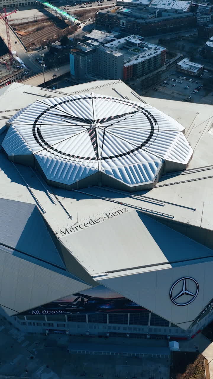 Atlanta, Georgia, USA - January 02, 2024: Aerial camera pans over the central logo on roof Mercedes-Benz Stadium. Vertical video