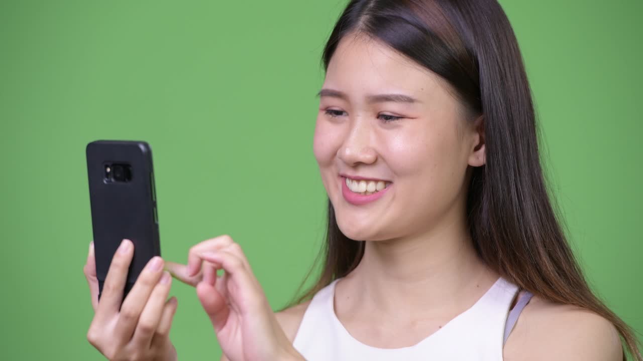 Young beautiful Asian businesswoman using phone