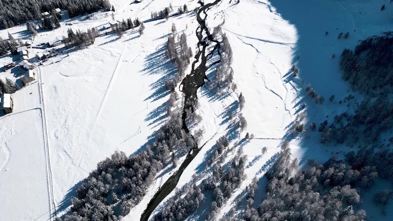 vista aérea del paisaje cubierto de nieve con bosques y ríos en un soleado día de invierno en alp grum, suiza