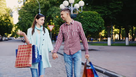 Joven-Pareja-Caminando-Por-La-Ciudad-Con-Bolsas-De-Compras-Están-Felices-Sonriendo-Hablando