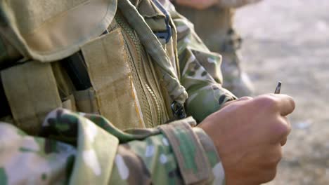 mid section of military soldier holding rifle magazine during training 4k