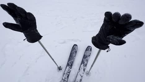 Slow-rotation-around-a-pair-of-ski-poles-winter-gloves-and-skis-in-a-blizzard-snow-condition-in-British-Columbia,-Canada
