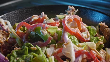 static shot of a finished tuna salad salad served in a black bowl