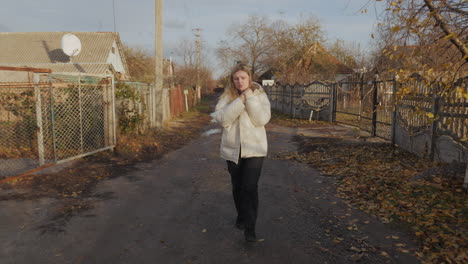 mujer caminando por un camino de campo en otoño