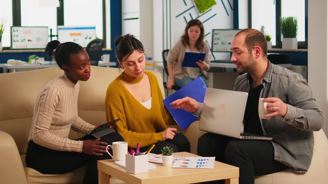 Start up team meeting with company leader pointing at strategy on financial reports