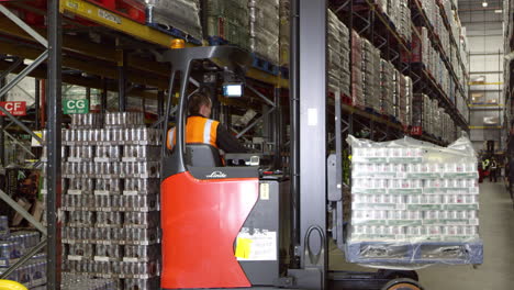 Forklift-driver-moving-full-pallet-in-warehouse,-shot-on-R3D