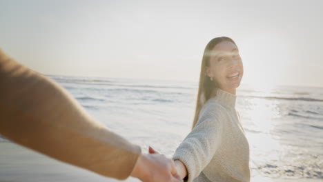 playa, puesta de sol y pareja cogida de la mano caminando