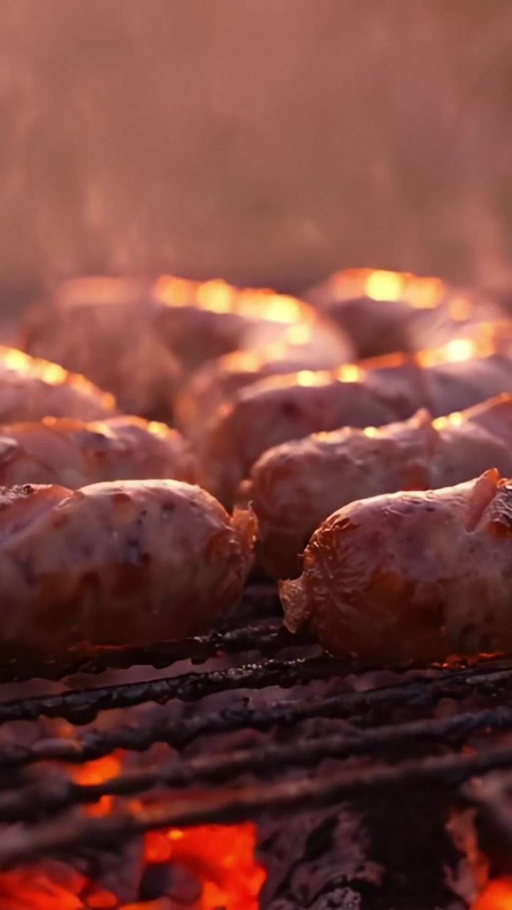 Scene Accattivanti di Grigliate: Salsicce Succose e Carne Deliziosa Che Sfrigolano sul Fuoco, Creando un'Atmosfera da Barbecue Che Fa Venire l'Acquolina in Bocca al Tramonto
