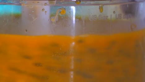 passion fruit pulp being separated from seeds in an electric mixer