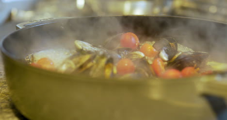 the cook cooks mussels in the pan 4