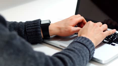 Mid-section-of-male-executive-using-laptop-at-desk