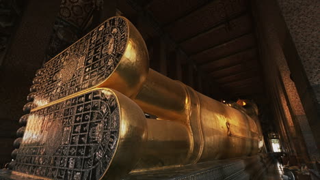 panning parallax shot of reclining buddha with feet inlaid with mother of pearl.