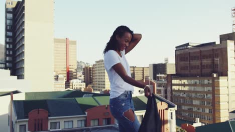 fashionable young woman on urban rooftop swinging her jacket