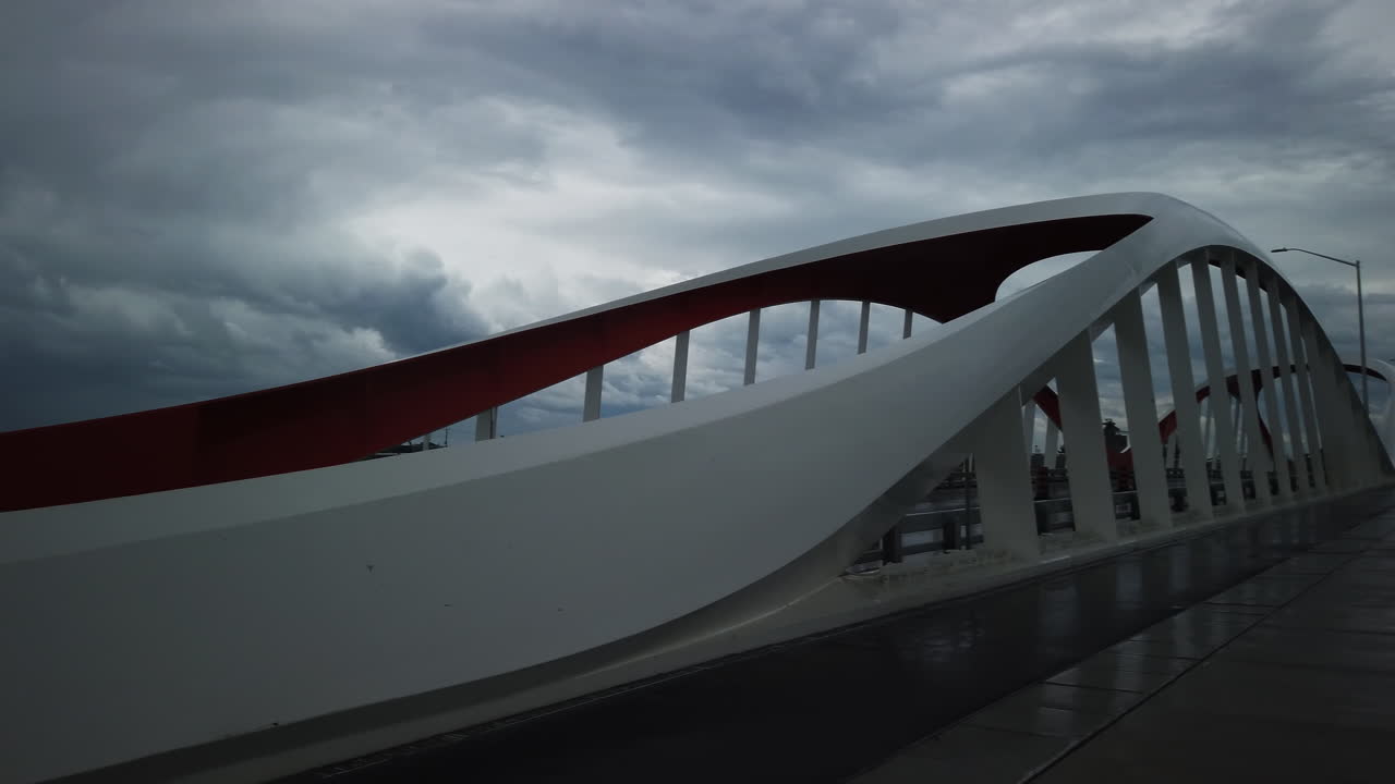 Rainy day view of Commissioners Street Bridge in Toronto with wet bike path and buildings in the background, pan right
