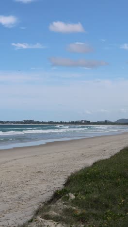 a tranquil beach scene with waves and shifting clouds.