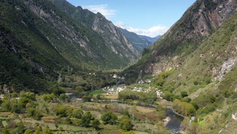 panoramic establishing view of stunning mountain town in tibetan sichuan western china as river winds below valley