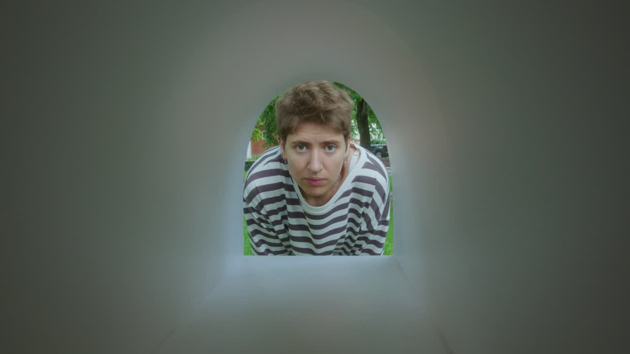 Upset Woman Staring at Camera through Empty Mailbox