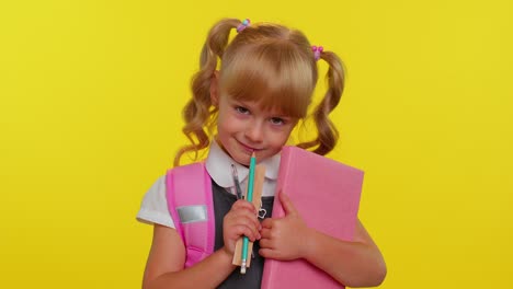 funny positive kid primary school girl with ponytails wearing uniform smiling on yellow background