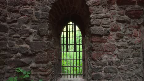 dolly push in towards metal grate in doorway of cemented brick stone historic structure